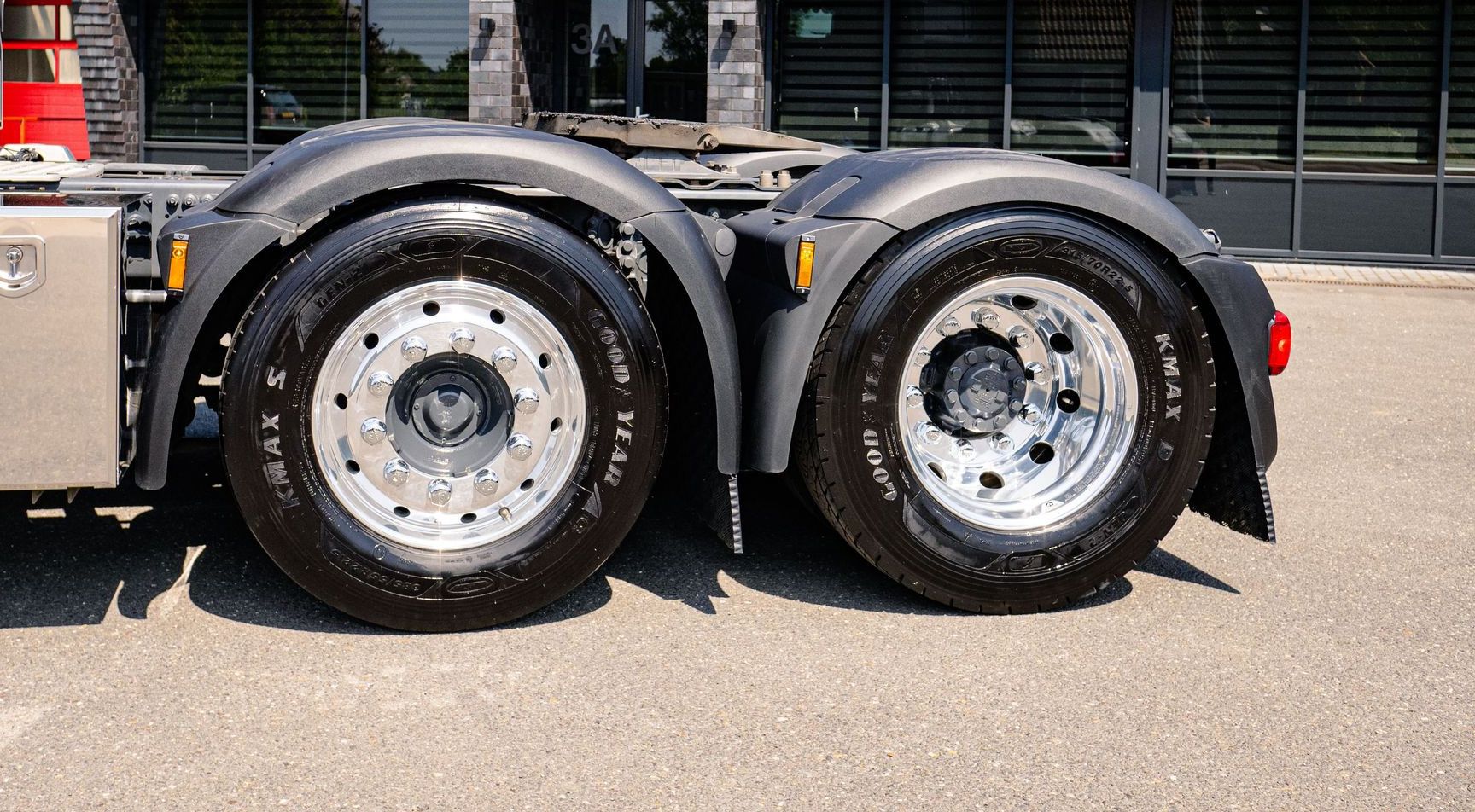 Detail of truck wheels with reflective building backdrop in Andijk, Netherlands.